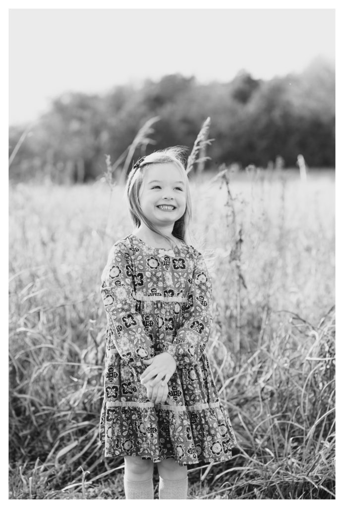 Fall Family/Lifestyle Photography Antietam MD - black & white - little girl in a dress smiling while standing in a field