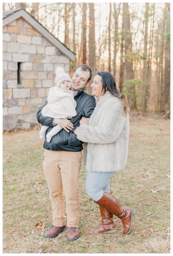 Winter Family Photos at Sugarloaf Mountain in Maryland - mother and father holding baby girl and smiling