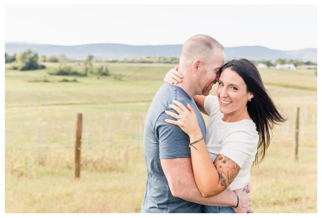 Autumn Vineyard Engagement Session - man and woman embracing and smiling with mountain view