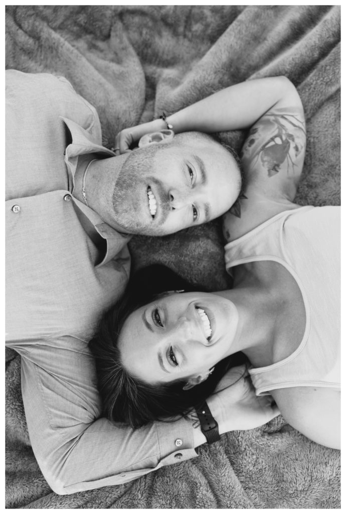 Autumn Vineyard Engagement Session - black and white photo of a couple laying down and smiling